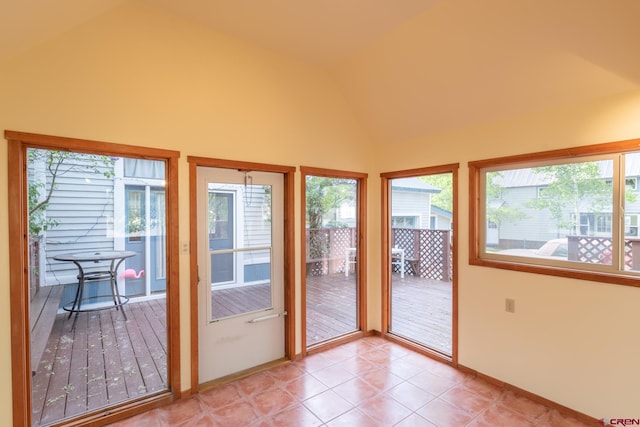 doorway to outside featuring light tile floors and vaulted ceiling