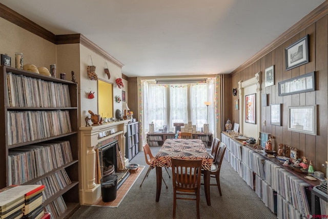 dining room featuring dark carpet, ornamental molding, and wood walls