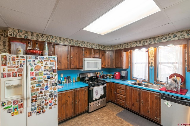 kitchen with a drop ceiling, appliances with stainless steel finishes, and sink