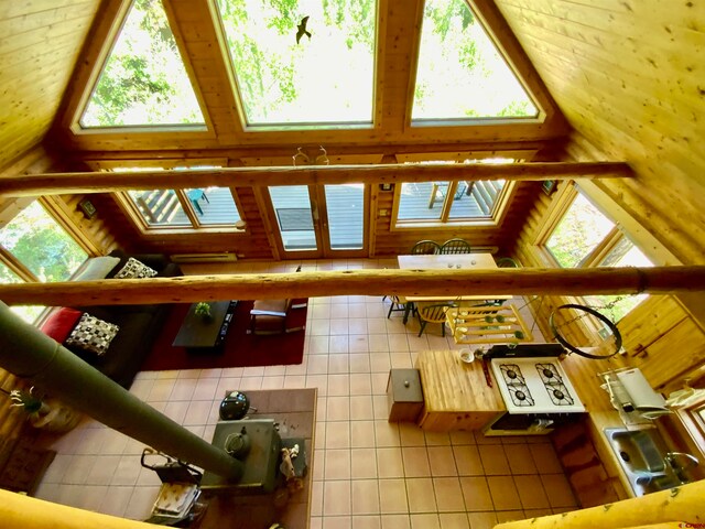 tiled living room with a skylight, high vaulted ceiling, and a wealth of natural light