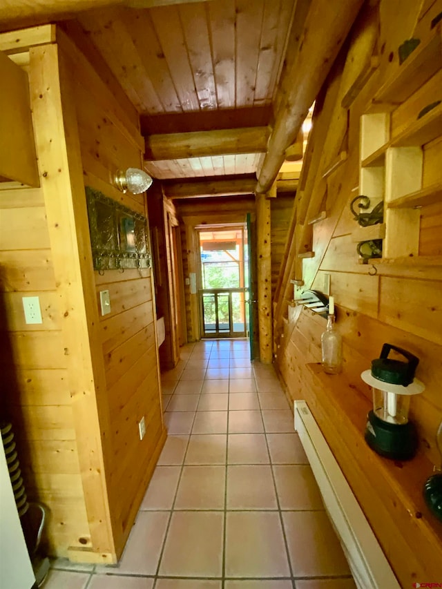 corridor with wood walls, wood ceiling, and light tile flooring