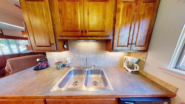 kitchen featuring backsplash, dishwasher, and sink