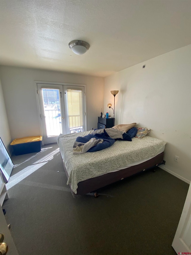 carpeted bedroom featuring a textured ceiling and french doors