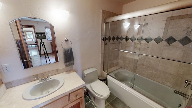 full bathroom with toilet, bath / shower combo with glass door, vanity, and tile flooring