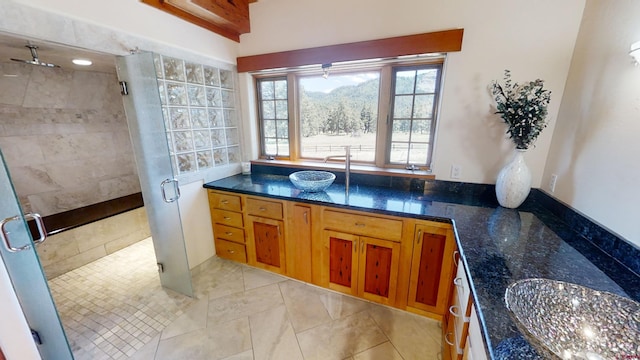 bathroom with tile flooring, walk in shower, and vanity