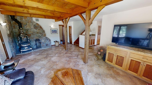 living room featuring light tile flooring, a wood stove, beamed ceiling, and wooden ceiling