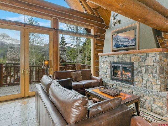 living room with beam ceiling, light tile floors, and a stone fireplace