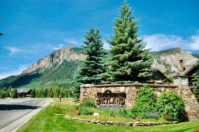 community / neighborhood sign with a mountain view