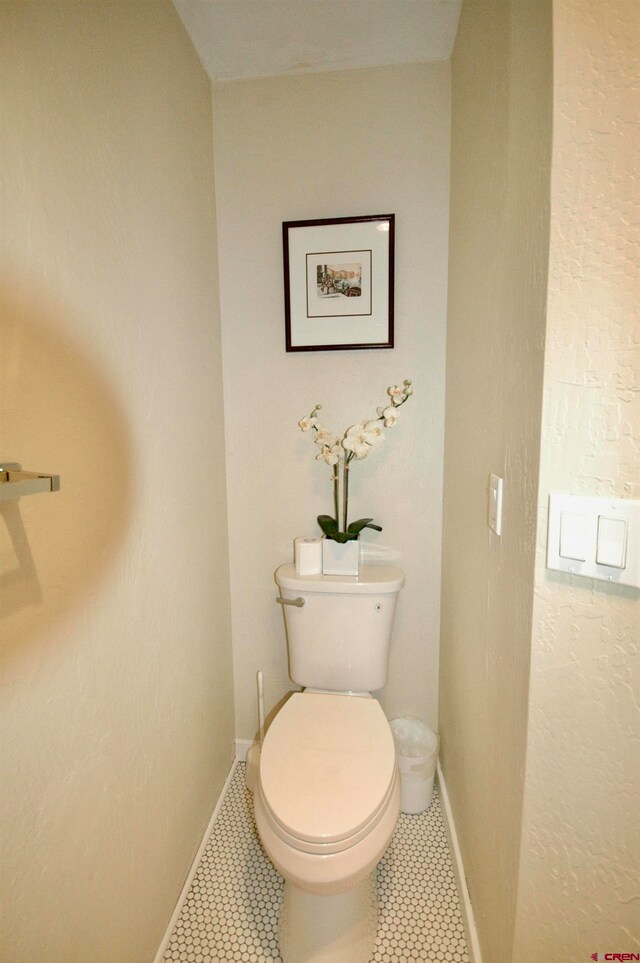 bathroom featuring toilet and tile floors