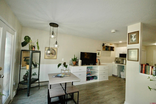 interior space featuring decorative light fixtures, dark hardwood / wood-style flooring, and white cabinets