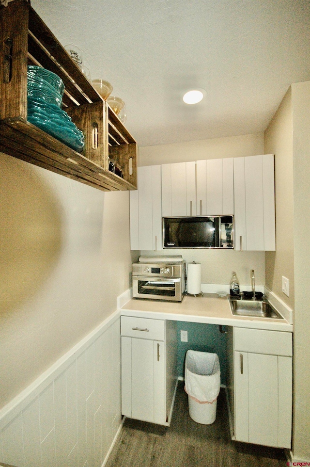 kitchen featuring dark hardwood / wood-style flooring, sink, and white cabinets