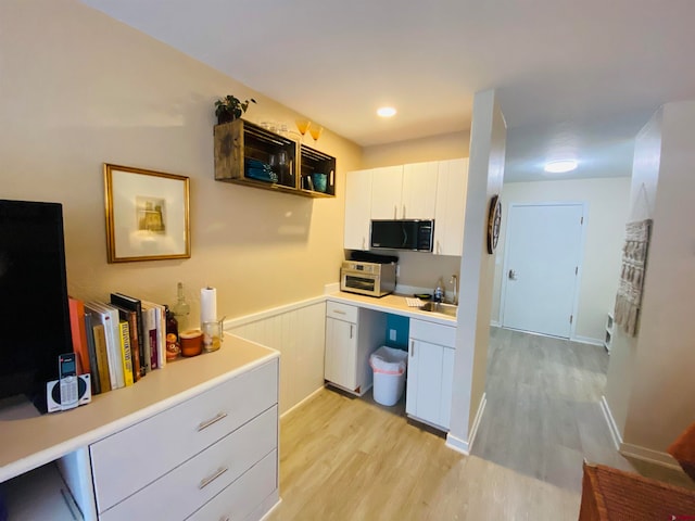 kitchen featuring light wood-type flooring and white cabinetry