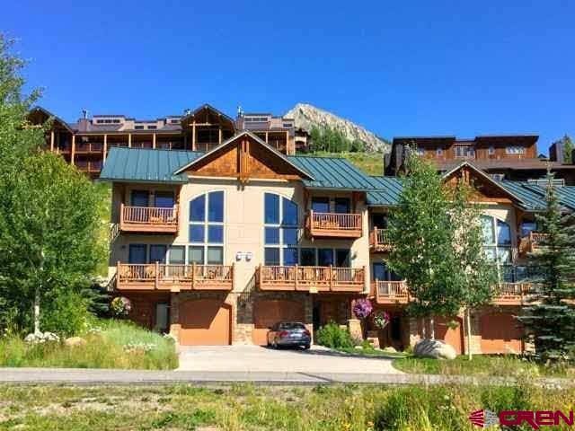 back of house with a balcony, a mountain view, and a garage