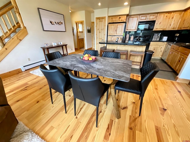 dining area with baseboard heating and light wood-type flooring