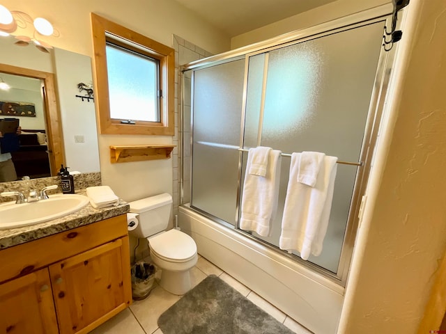 full bathroom with oversized vanity, combined bath / shower with glass door, toilet, and tile floors