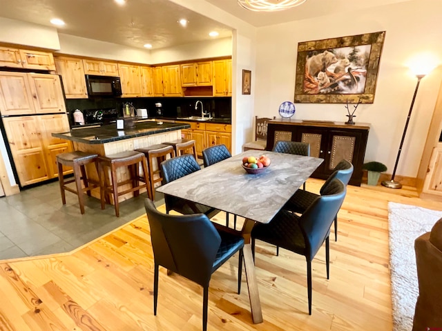 dining room with sink and light wood-type flooring