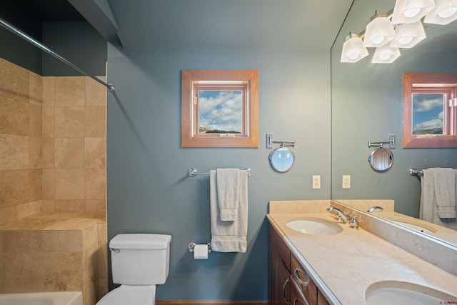 bathroom featuring dual bowl vanity and toilet