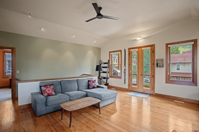 living room with ceiling fan, lofted ceiling, and light hardwood / wood-style floors