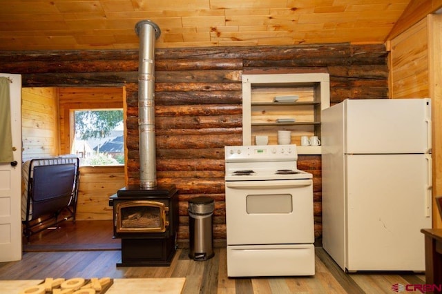 289 S Main St, Creede, CO 81130 - kitchen featuring a wood stove, rustic walls, wood finished floors, and white appliances