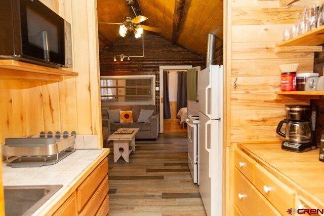 289 S Main St, Creede, CO 81130 - kitchen featuring ceiling fan, wood ceiling, wood finished floors, tile counters, and vaulted ceiling with beams