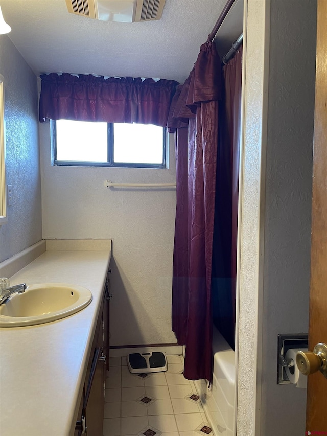 bathroom featuring shower / bath combination with curtain, plenty of natural light, tile flooring, and vanity