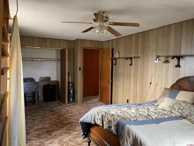 bedroom with wooden walls, ceiling fan, light carpet, a textured ceiling, and a closet