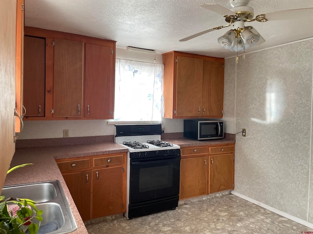 kitchen featuring ceiling fan, sink, a textured ceiling, and gas range gas stove