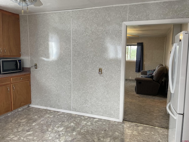 interior space with white fridge, ceiling fan, and tile flooring