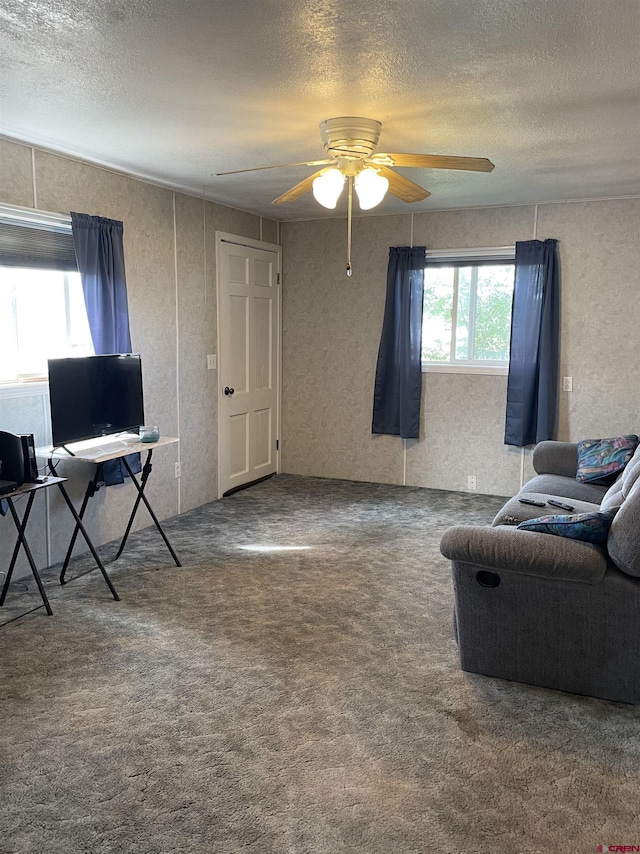 interior space with ceiling fan, dark carpet, and a textured ceiling