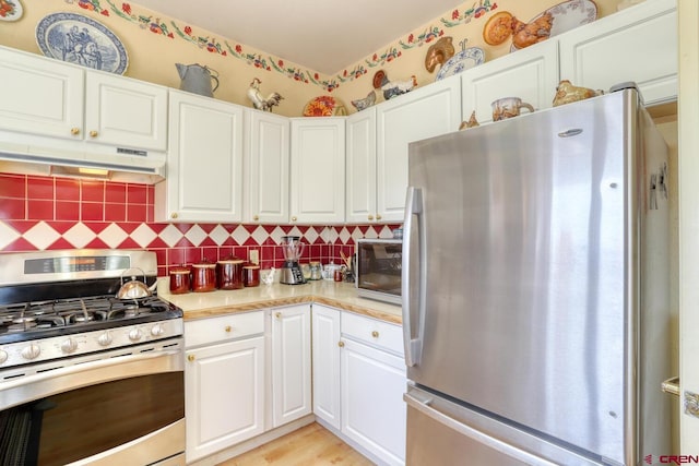 kitchen featuring white cabinets, tasteful backsplash, light hardwood / wood-style floors, and appliances with stainless steel finishes