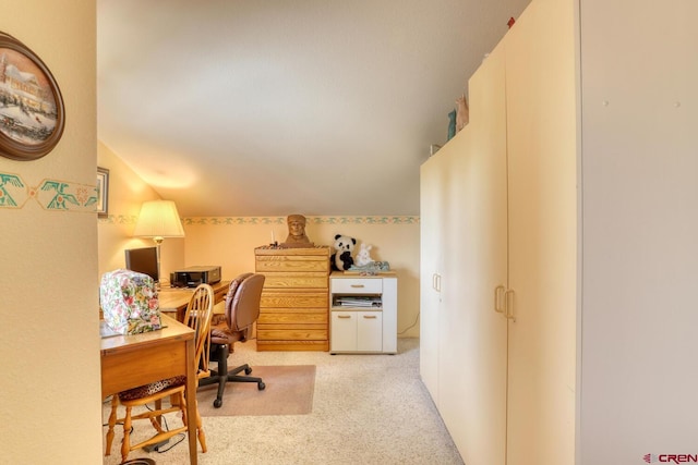 home office featuring light carpet and vaulted ceiling