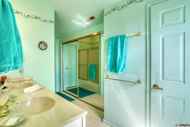 bathroom featuring dual vanity, tile floors, and a shower with shower door