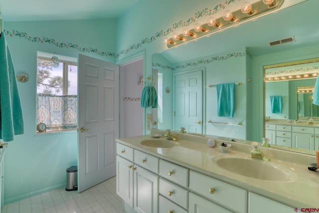 bathroom featuring double sink vanity, tile floors, and vaulted ceiling