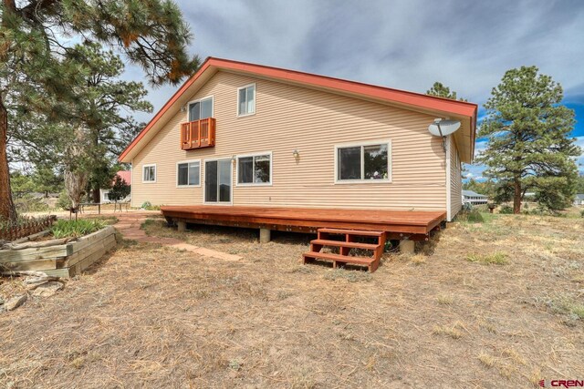 rear view of house featuring a wooden deck