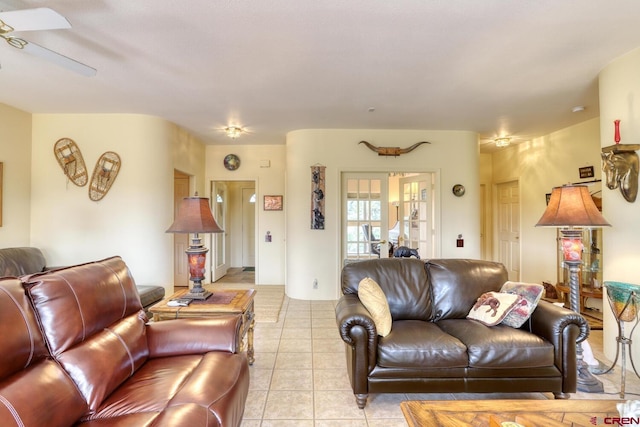 tiled living room featuring ceiling fan and french doors