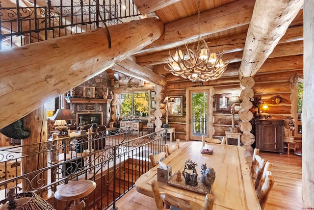 dining area featuring rustic walls, vaulted ceiling with beams, a notable chandelier, light hardwood / wood-style flooring, and wooden ceiling