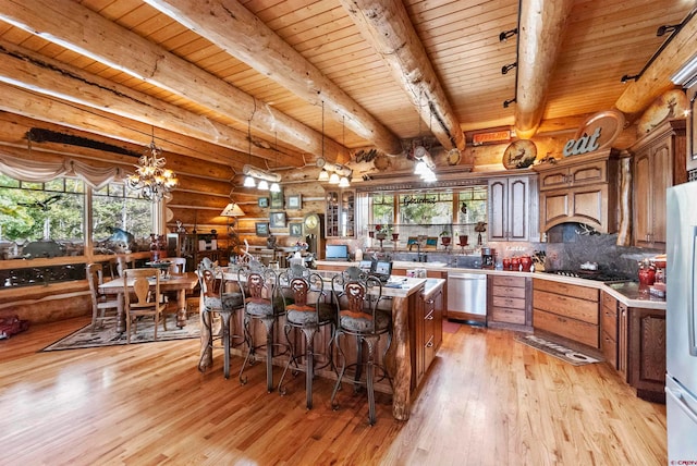 kitchen with log walls, a notable chandelier, wood ceiling, and beamed ceiling