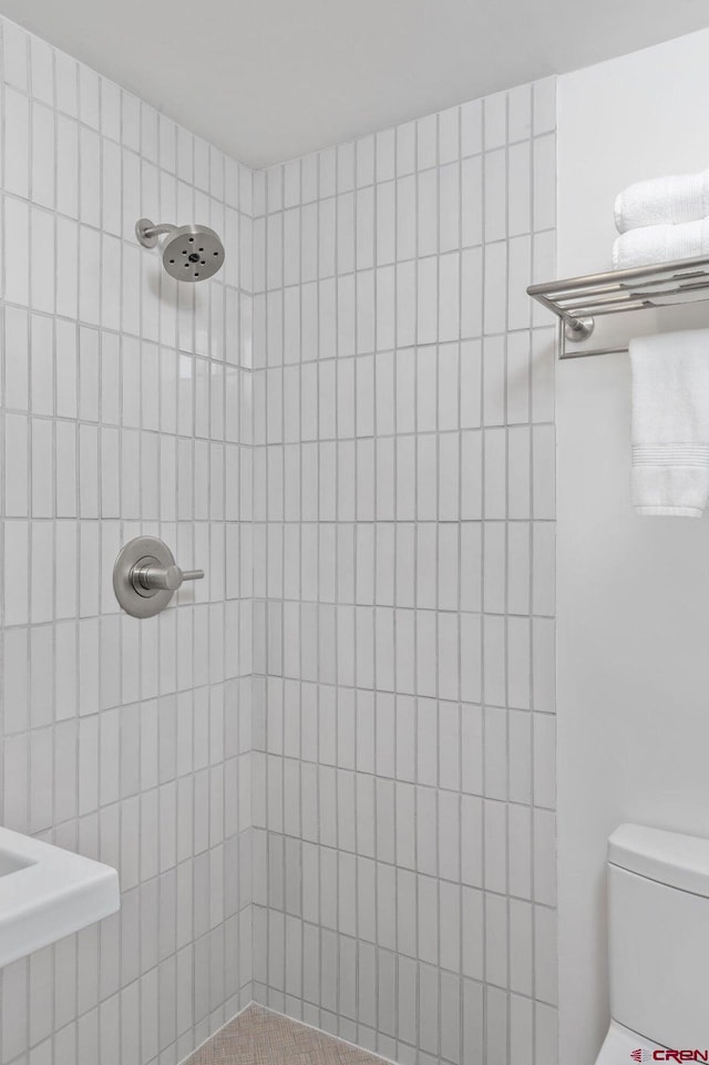 bathroom with toilet and tiled shower