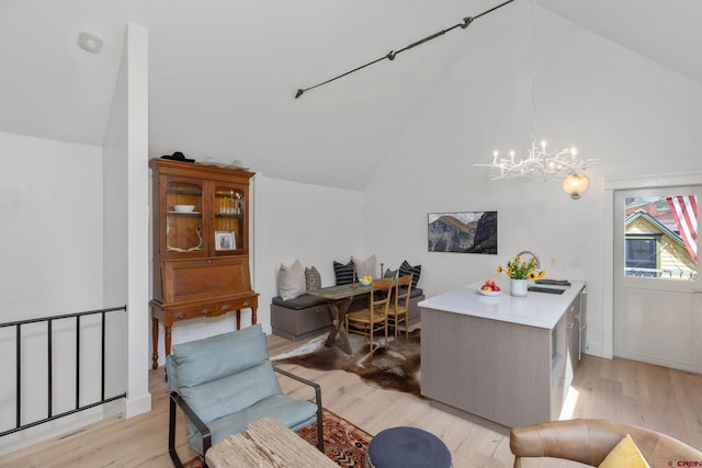 office with lofted ceiling, light wood-type flooring, and an inviting chandelier