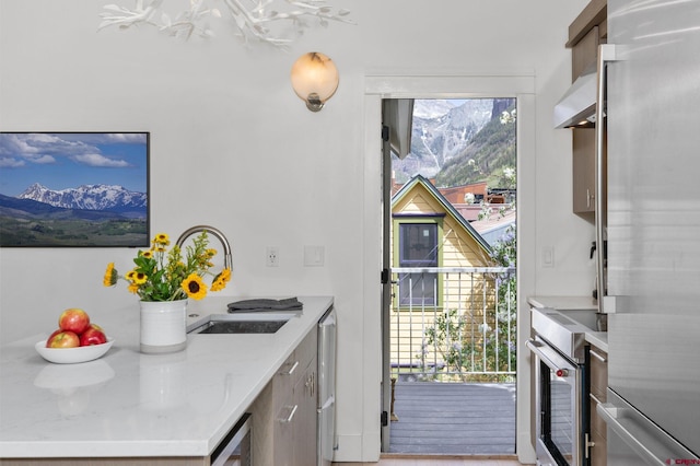 kitchen featuring appliances with stainless steel finishes, sink, a wealth of natural light, and a mountain view