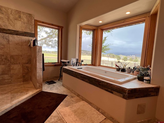 bathroom featuring a bath, a wealth of natural light, and tile floors