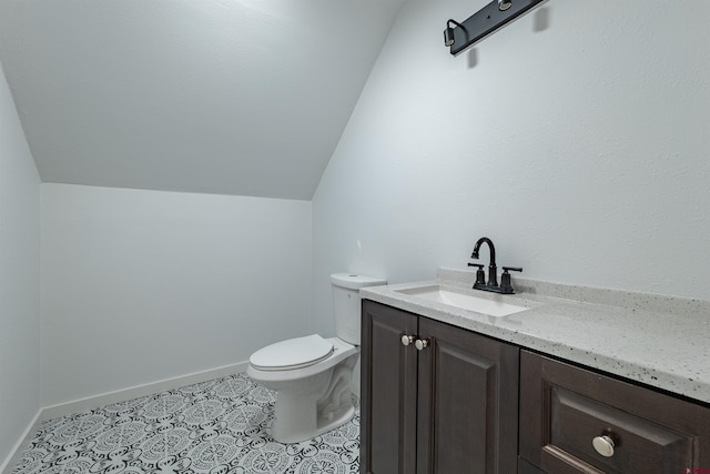 bathroom with lofted ceiling, tile flooring, toilet, and vanity