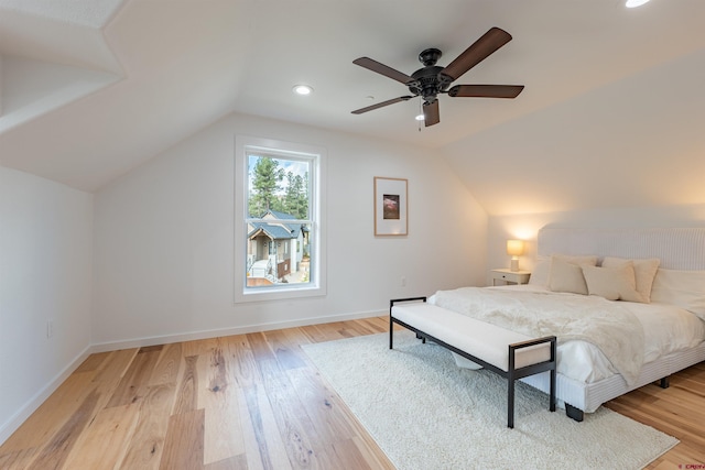 bedroom featuring ceiling fan, light wood-type flooring, and vaulted ceiling