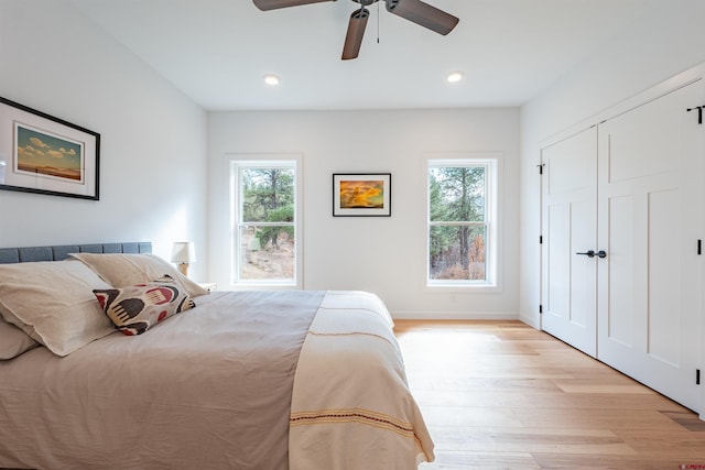 bedroom featuring ceiling fan, a closet, and light hardwood / wood-style flooring