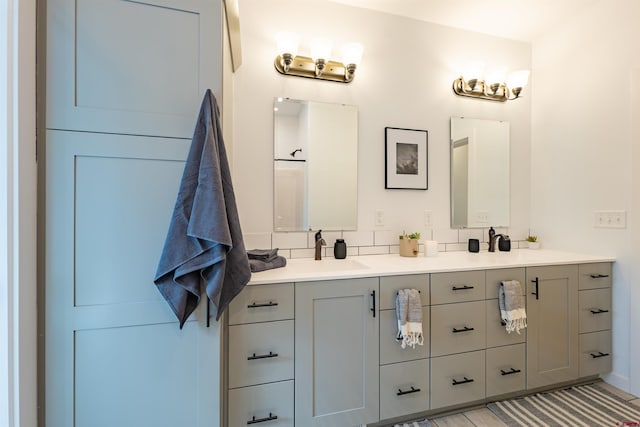 bathroom with tasteful backsplash and double sink vanity