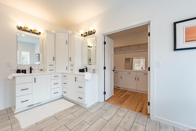 bathroom with large vanity and wood-type flooring