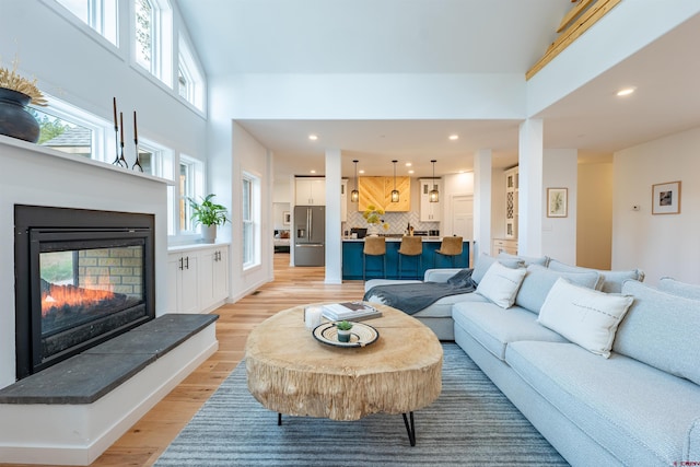 living room featuring a high ceiling and light hardwood / wood-style floors