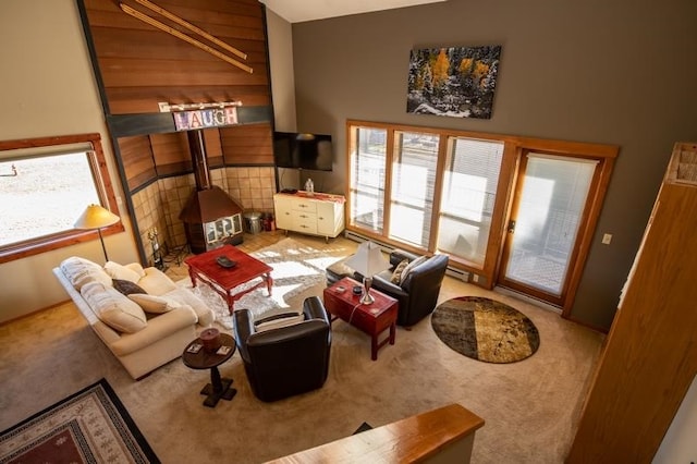 living room with a towering ceiling, wooden walls, and carpet