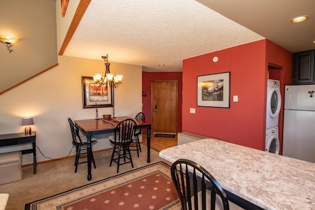 carpeted dining room with stacked washer and clothes dryer, a textured ceiling, and an inviting chandelier