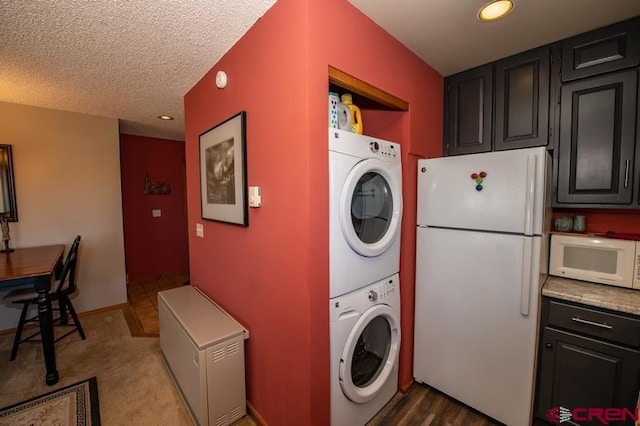 washroom featuring a textured ceiling, stacked washer / drying machine, and carpet flooring